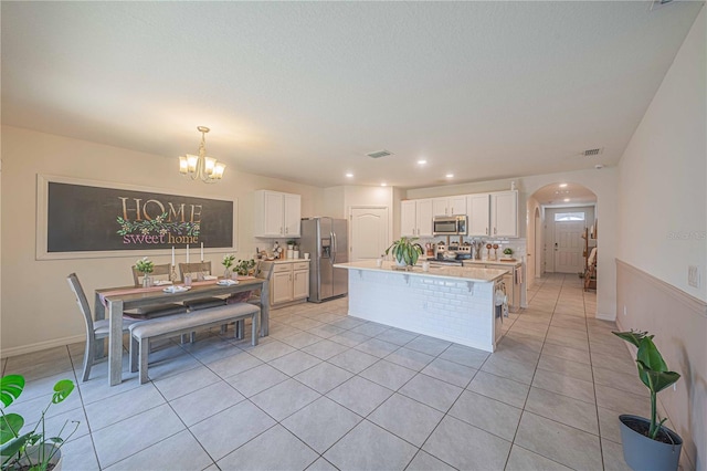 3719 Holly Grove Ln, Mount Dora, FL 32757 - kitchen with appliances with stainless steel finishes, a chandelier, light countertops, arched walkways, and white cabinets