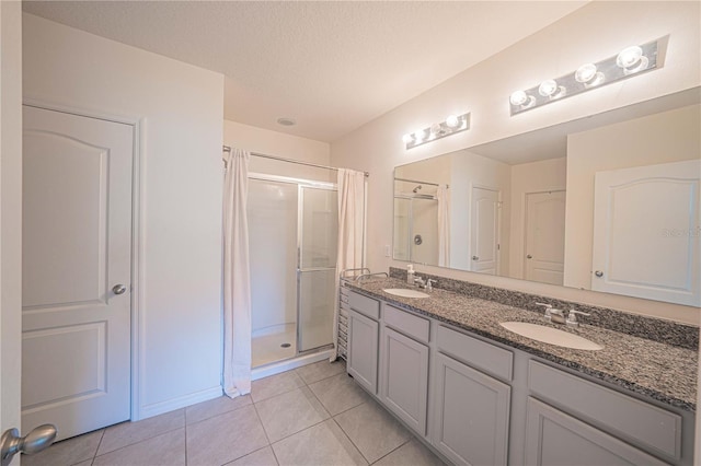 3719 Holly Grove Ln, Mount Dora, FL 32757 - bathroom with a stall shower, tile patterned floors, double vanity, a textured ceiling, and baseboards