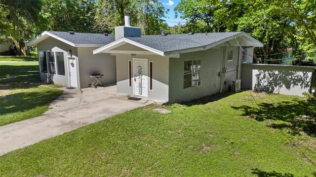 3058 SE 3rd Ave, Ocala, FL 34471 - view of front of house with stucco siding, cooling unit, a front lawn, and roof with shingles