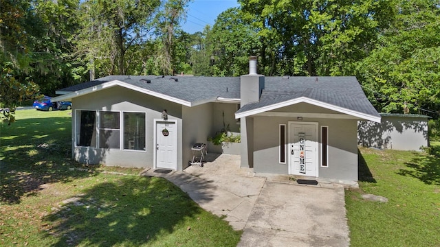 3058 SE 3rd Ave, Ocala, FL 34471 - view of front facade featuring stucco siding, a chimney, a front lawn, and roof with shingles