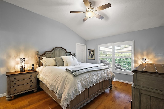 bedroom with dark wood-style flooring, a ceiling fan, baseboards, and vaulted ceiling