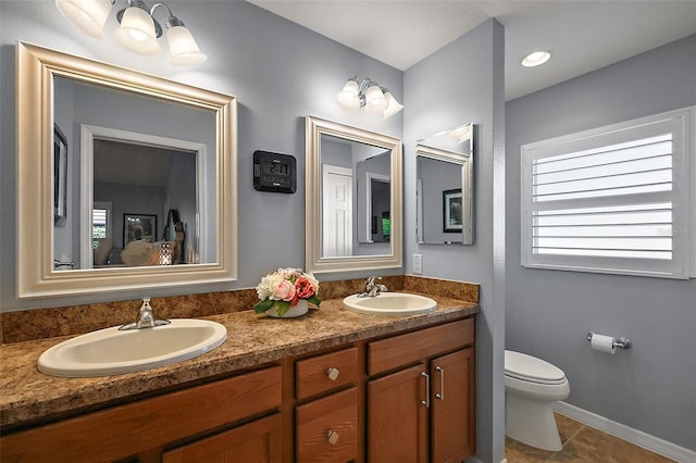 full bath featuring a sink, toilet, double vanity, and tile patterned flooring