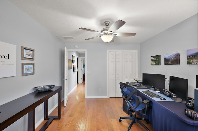 office space with visible vents, a ceiling fan, baseboards, and light wood finished floors