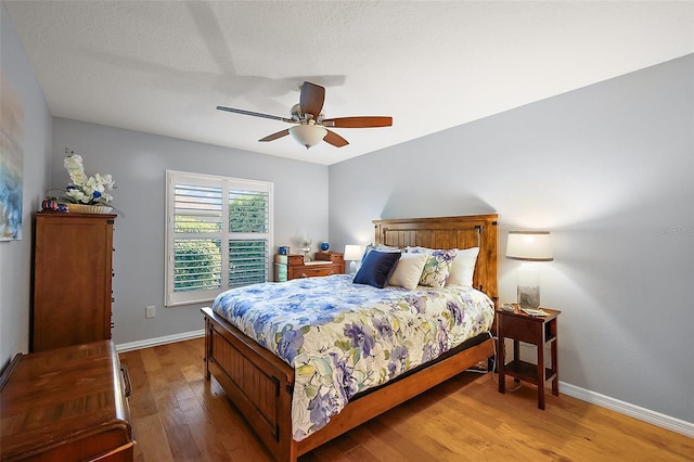 bedroom with light wood finished floors, ceiling fan, and baseboards