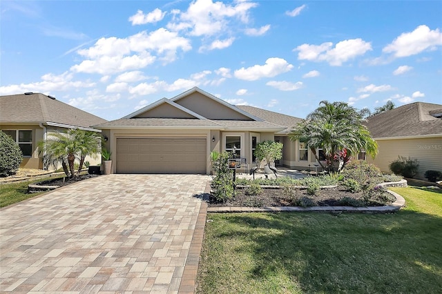 single story home with stucco siding, a front yard, decorative driveway, and a garage