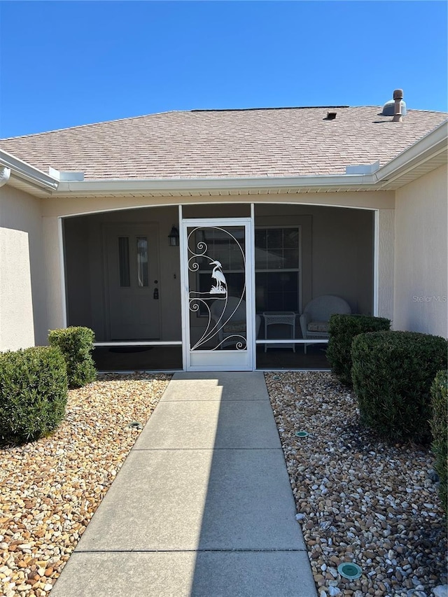 doorway to property featuring roof with shingles