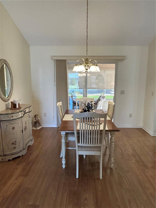 dining area with a chandelier, baseboards, and wood finished floors