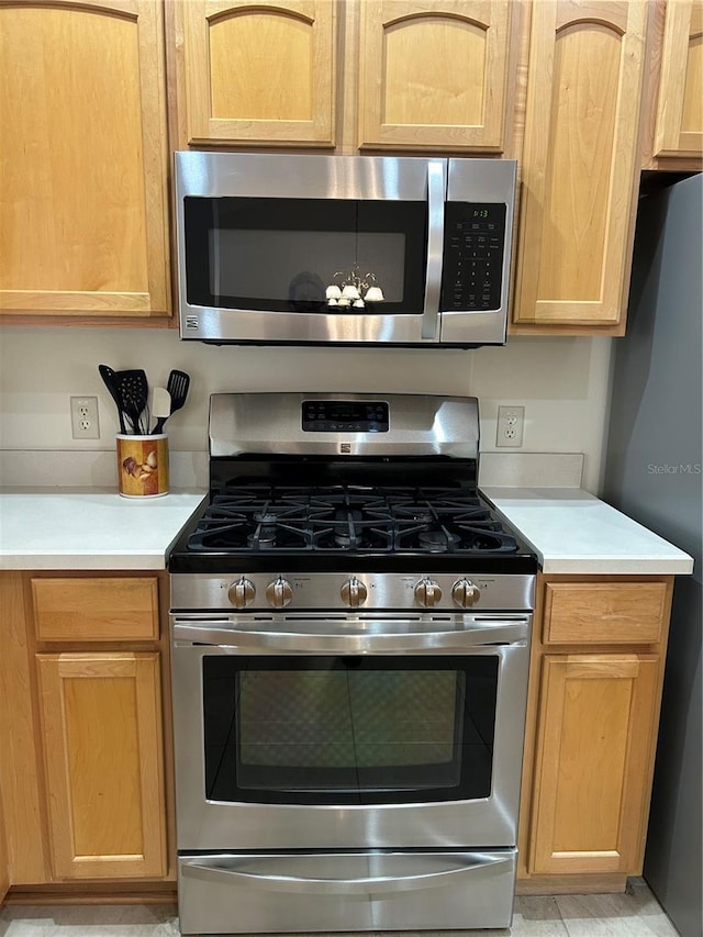 kitchen with light countertops, appliances with stainless steel finishes, and light brown cabinetry