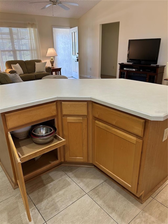 kitchen featuring open floor plan, light tile patterned flooring, light countertops, lofted ceiling, and ceiling fan