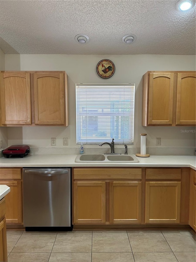 kitchen featuring dishwasher, a textured ceiling, light countertops, and a sink