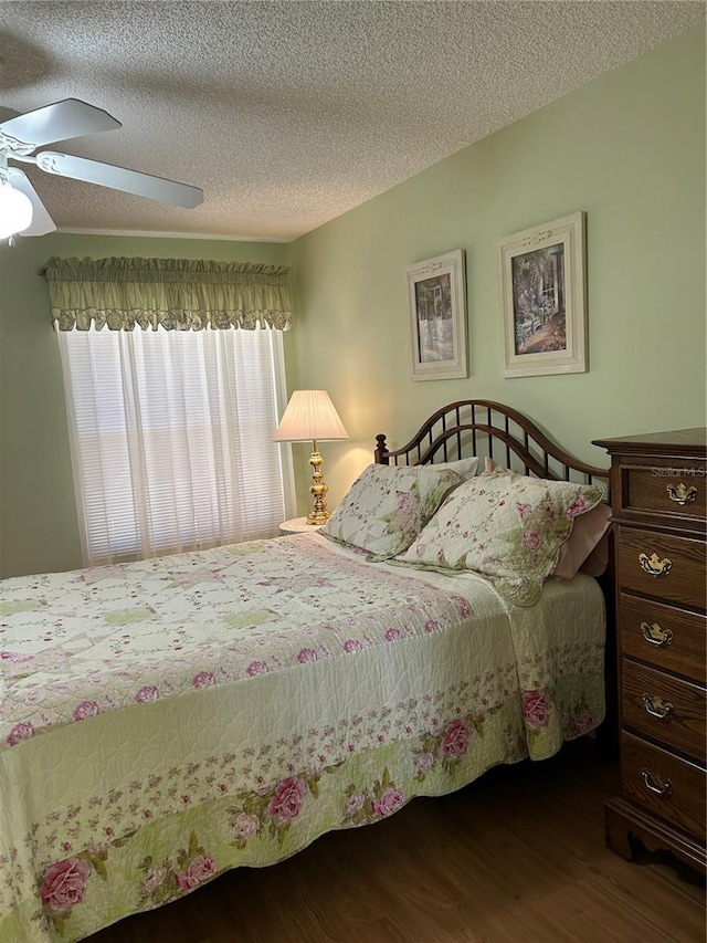 bedroom featuring ceiling fan, a textured ceiling, wood finished floors, and vaulted ceiling