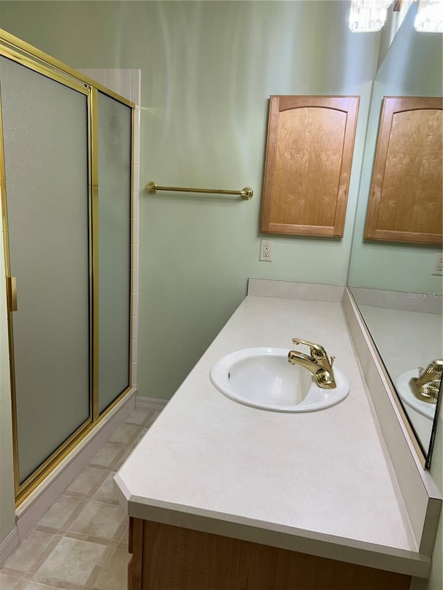 bathroom with a shower stall and vanity