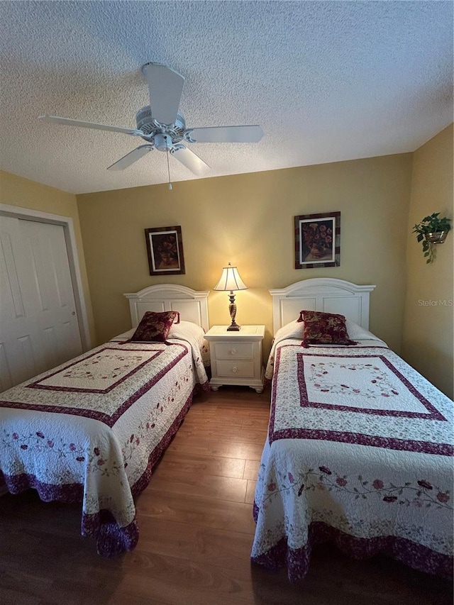 bedroom featuring a closet, a textured ceiling, wood finished floors, and a ceiling fan