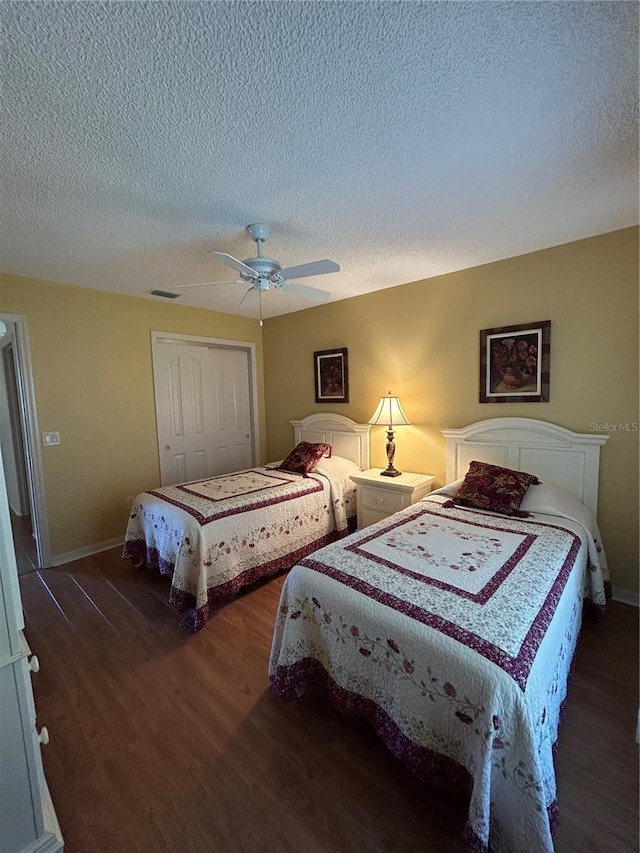 bedroom with visible vents, ceiling fan, wood finished floors, a closet, and a textured ceiling