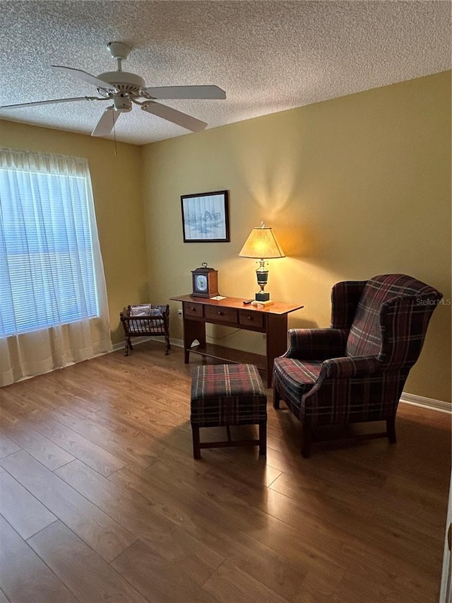 office area with ceiling fan, baseboards, a textured ceiling, and wood finished floors