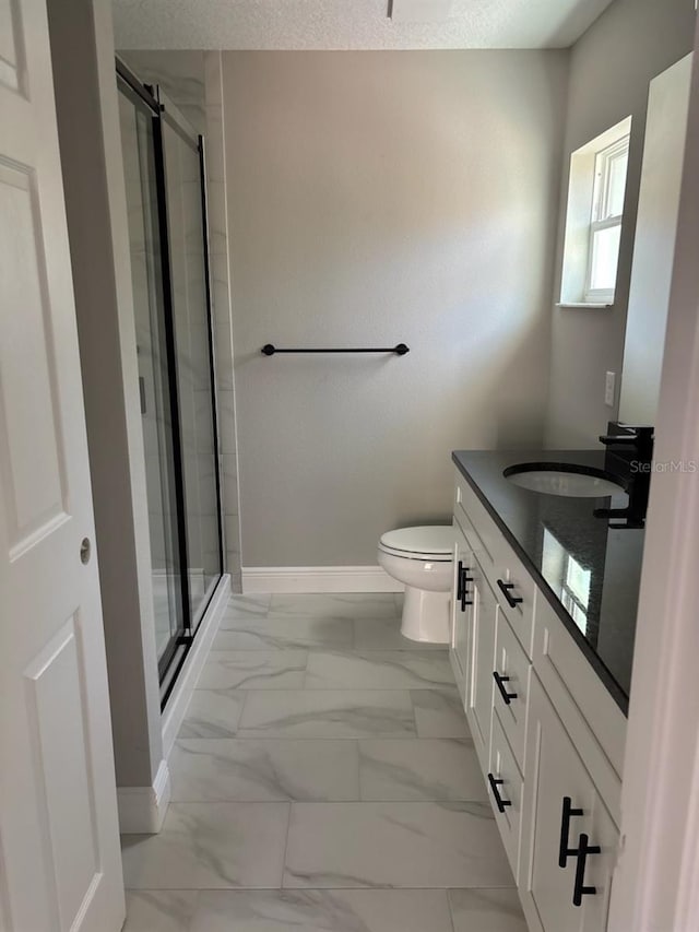 bathroom with vanity, baseboards, a stall shower, toilet, and marble finish floor