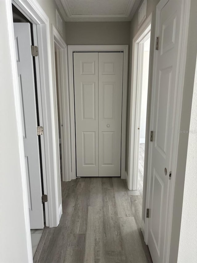 hall with wood finished floors and visible vents