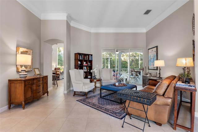 living room featuring arched walkways, visible vents, crown molding, and light tile patterned floors