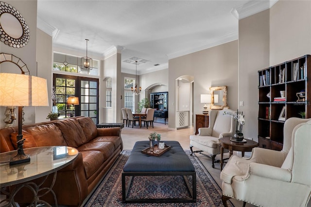 living area featuring a chandelier, arched walkways, and ornamental molding