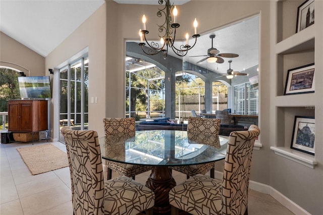 dining room with tile patterned floors, a healthy amount of sunlight, baseboards, and lofted ceiling