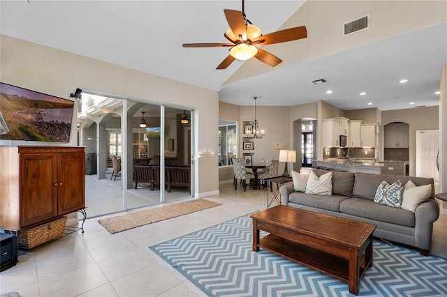 living area featuring visible vents, arched walkways, and ceiling fan with notable chandelier