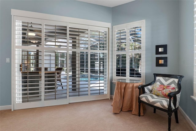 sitting room with plenty of natural light, carpet, and baseboards