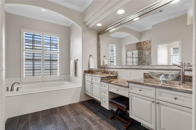 full bathroom with visible vents, crown molding, wood finished floors, a bath, and a sink