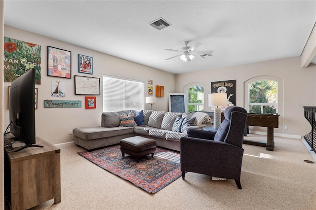 carpeted living area with visible vents, baseboards, and a ceiling fan