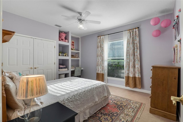 carpeted bedroom with a ceiling fan, a closet, and baseboards