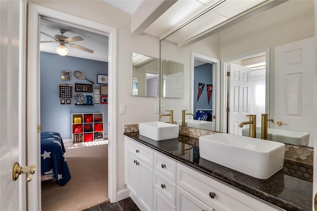 bathroom featuring a sink, baseboards, ceiling fan, and double vanity