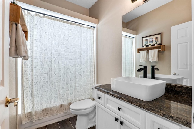 bathroom featuring shower / tub combo with curtain, toilet, vanity, and wood finished floors