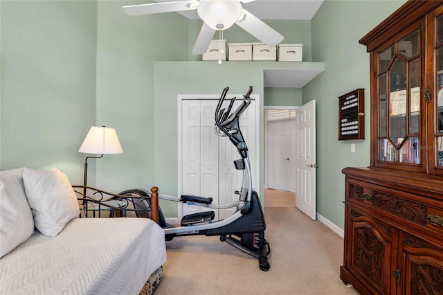 carpeted bedroom with a closet and baseboards