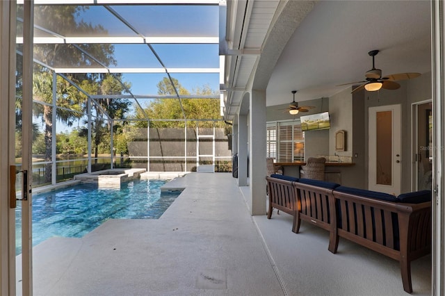 view of pool featuring a patio, a ceiling fan, a pool with connected hot tub, and a lanai