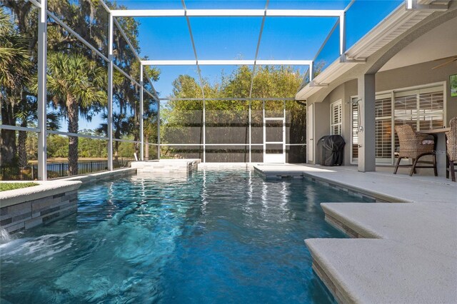 view of swimming pool featuring a patio area, glass enclosure, and a fenced in pool