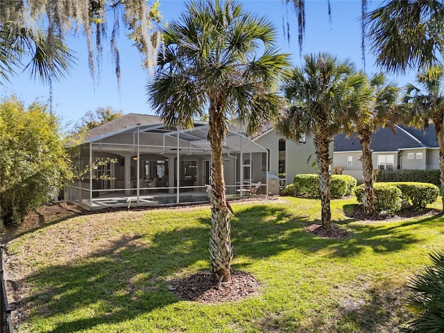 back of property featuring glass enclosure, a lawn, and stucco siding