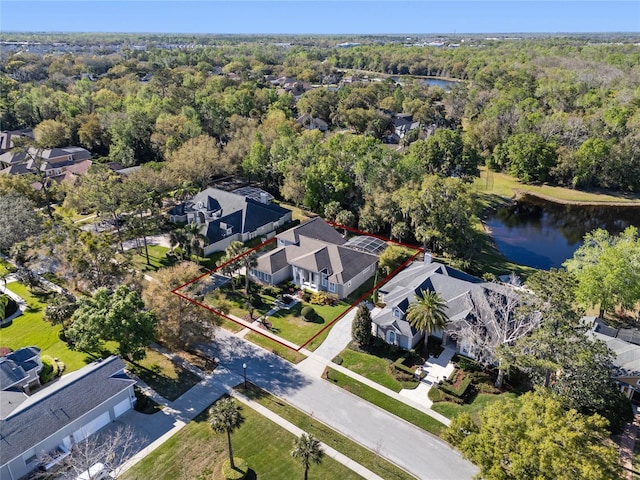 aerial view featuring a residential view, a water view, and a wooded view