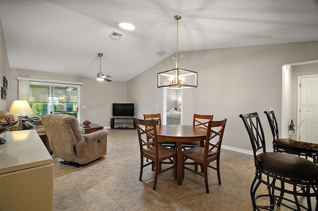 dining space with visible vents, a ceiling fan, a textured ceiling, baseboards, and vaulted ceiling