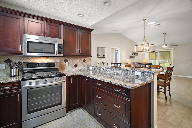 kitchen with visible vents, lofted ceiling, a peninsula, a kitchen breakfast bar, and stainless steel appliances