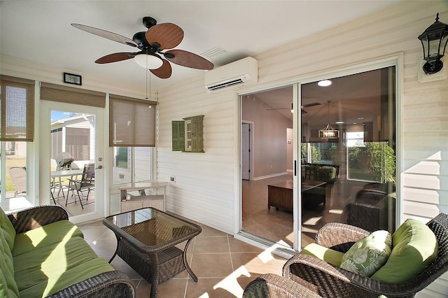 sunroom featuring visible vents, a ceiling fan, and a wall mounted AC