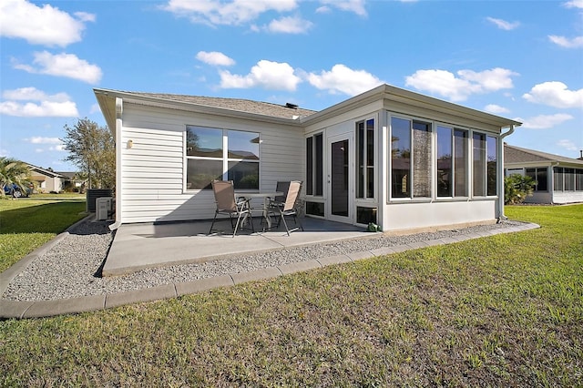 rear view of property featuring a yard, a patio area, and a sunroom