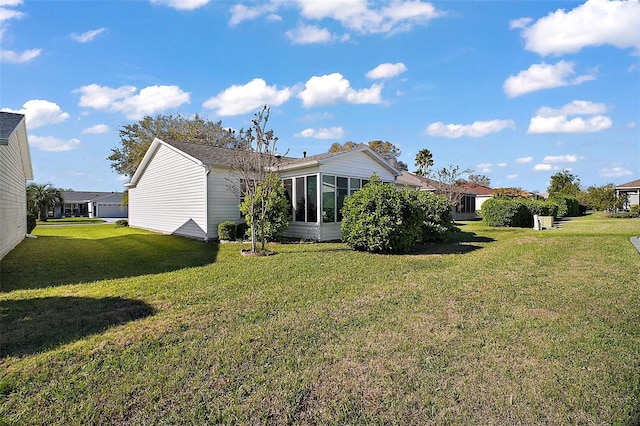 back of property with a lawn and a sunroom