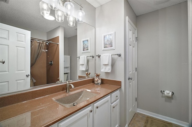 bathroom with vanity, a shower with curtain, baseboards, tile patterned flooring, and a textured ceiling