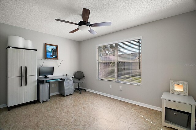 home office with a textured ceiling, a ceiling fan, and baseboards