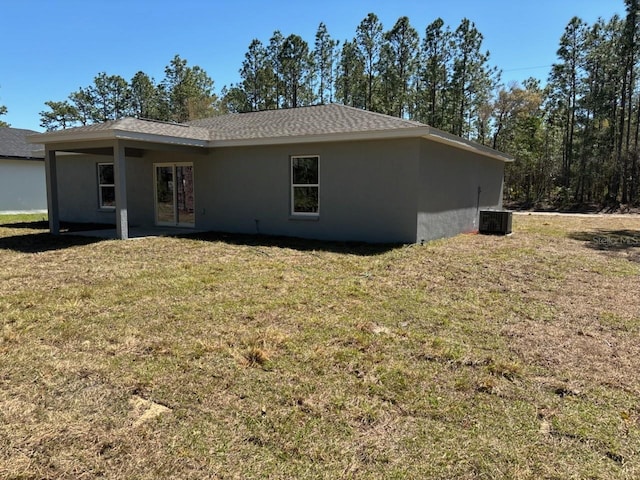 back of house featuring a yard, central AC unit, french doors, and stucco siding