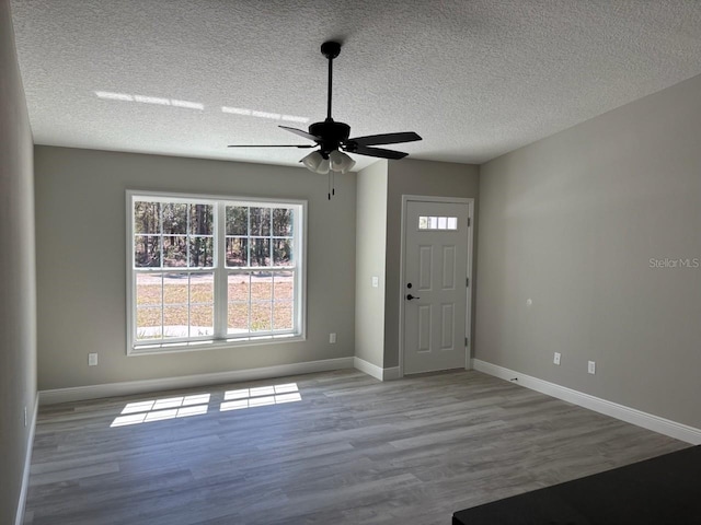 entryway featuring baseboards, a textured ceiling, wood finished floors, and a ceiling fan