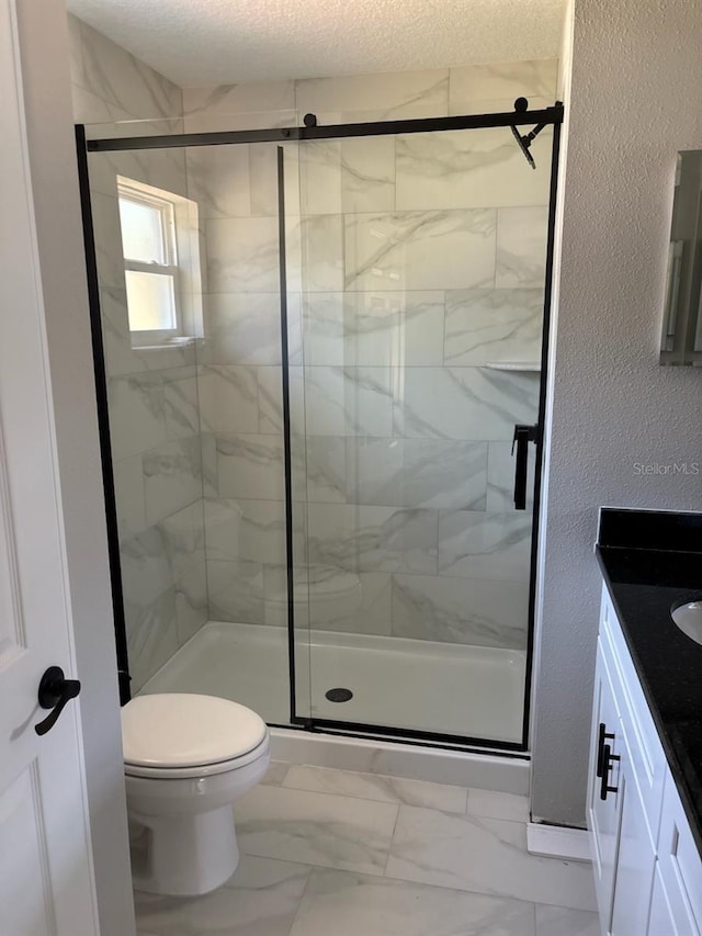 full bathroom with toilet, a stall shower, a textured wall, marble finish floor, and vanity