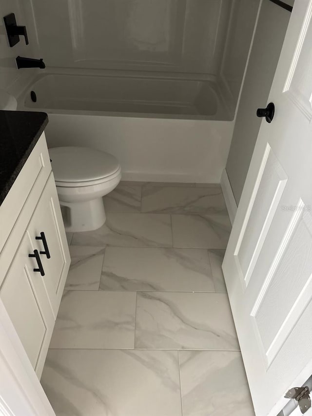 full bath with vanity, toilet, marble finish floor, and shower / bathtub combination