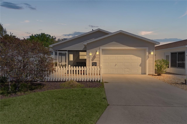 view of front of house with a sunroom, an attached garage, and driveway