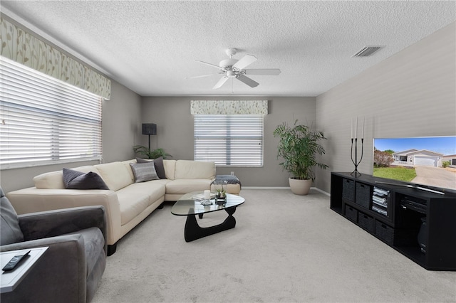 living room with a ceiling fan, carpet, visible vents, and a textured ceiling