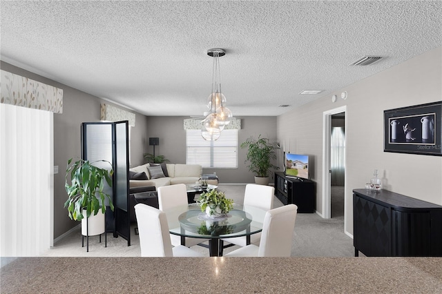 dining room with a notable chandelier, carpet flooring, visible vents, and a textured ceiling